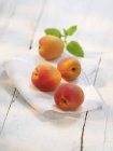 Vineyard peaches with leaves on fabric — Stock Photo