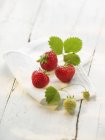 Strawberries with leaves on cloth — Stock Photo