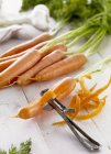 Carottes fraîches et écorces de carotte — Photo de stock