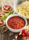 Tomato sauce and bowl of spaghetti — Stock Photo