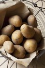 Potatoes in wire basket — Stock Photo