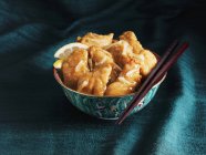 Vista de cerca del pollo chino al limón en un tazón con palillos - foto de stock