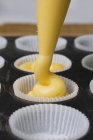 Muffin mix being piped into muffin cases — Stock Photo