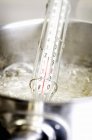 Closeup view of boiling sugar syrup with a thermometer — Stock Photo