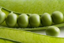 Fresh peas in opened pod — Stock Photo