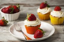Erdbeer-Cupcakes mit Sahne belegt — Stockfoto