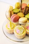 Cupcakes e macaroons na banca de bolo — Fotografia de Stock