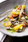 Smoked herring, onion and orange salad on plate — Stock Photo