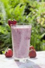 Strawberry smoothie outdoors — Stock Photo