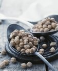 Chick-peas in spoons and over wooden surface — Stock Photo