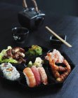 Comida japonesa em prato preto — Fotografia de Stock