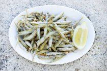 Fried sardines with lemon — Stock Photo