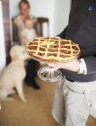 Closeup view of man serving a pecan pie on a cake stand — Stock Photo