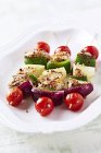 Тарілка курячих і овочевих шампурів на білій тарілці — стокове фото