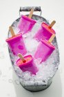 Nahaufnahme einer Zinkwanne gefüllt mit Crushed Ice und fünf Eislutschern — Stockfoto