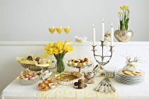 Diferentes pratos com bebidas, talheres, louças e velas na mesa — Fotografia de Stock