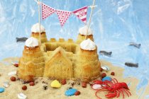Pastel de castillo de arena con decoraciones de playa - foto de stock