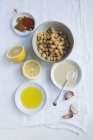 Ingredientes para húmus: grão de bico, tahini, alho, limão, azeite, páprica e cominho — Fotografia de Stock