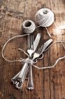 Повышенный вид на связки ножей и вилок с кухонной веревкой — стоковое фото