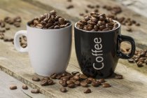 Tassen mit Kaffeebohnen gefüllt — Stockfoto