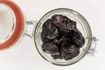 Closeup top view of glass jar with prunes — Stock Photo