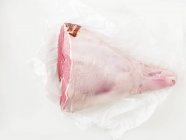 Сырая нога ягненка на листе бумаги — стоковое фото