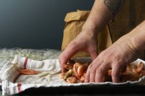 Chef filling paper bag with prawns — Stock Photo