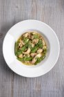 Grünes Curry mit Hühnchen und Bohnen auf weißem Teller über hölzerner Oberfläche — Stockfoto