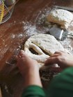 Обрезанный повышенный вид рук, делающих Fougasse с сырым тестом — стоковое фото