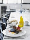 Una colazione all'inglese con uova e carne su un piatto bianco sul tavolo — Foto stock