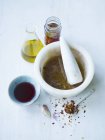 Салатні заправки з чилі, анчоусів, часнику та оливкової олії на білій поверхні — стокове фото
