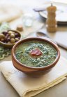 Caldo verde - potato and green kale soup with chorizo in bowl over towel — Stock Photo