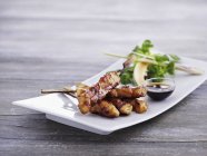 Closeup view of Satay skewers with soy sauce — Stock Photo