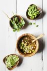 Miso soup with potatoes, white cabbage and soy beans over wooden surface — Stock Photo