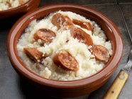 Closeup view of grits with sausage slices — Stock Photo