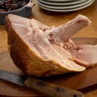 Partially sliced ham with bone — Stock Photo