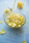Closeup view of pouring water to a bowl with yellow rose petals — Stock Photo