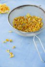 Closeup view of dried yellow rose petals in a sieve — Stock Photo