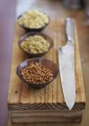 Uncooked spelt, freekeh and bulgur in bowls — Stock Photo