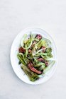 Огірки салат з тунцем на тарілку, на білій поверхні — стокове фото