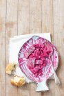 Herring salad with beetroot, gherkins, egg, apple and mayonnaise over wooden surface — Stock Photo