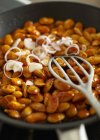 Baked beans with onions as part of an English breakfast in pan with server — Stock Photo