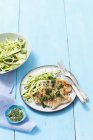 Grilled turkey breast with parsley pesto and courgette strips over blue wooden surface — Stock Photo