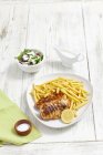 Closeup view of grilled chicken breast with chips and salad — Stock Photo