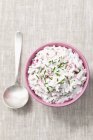 Radish quark with chives over wooden surface with spoon — Stock Photo