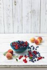 Чорниця з червоною смородиною та персиками — стокове фото