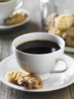 Black coffee with biscuits — Stock Photo