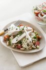 Peito de frango en papillote em uma salada de legumes em placa branca com garfo sobre mesa — Fotografia de Stock