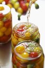 Tomates preservados em jarros sobre fundo branco — Fotografia de Stock