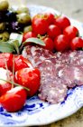 Plateau avec salami tranché et tomates cerises — Photo de stock